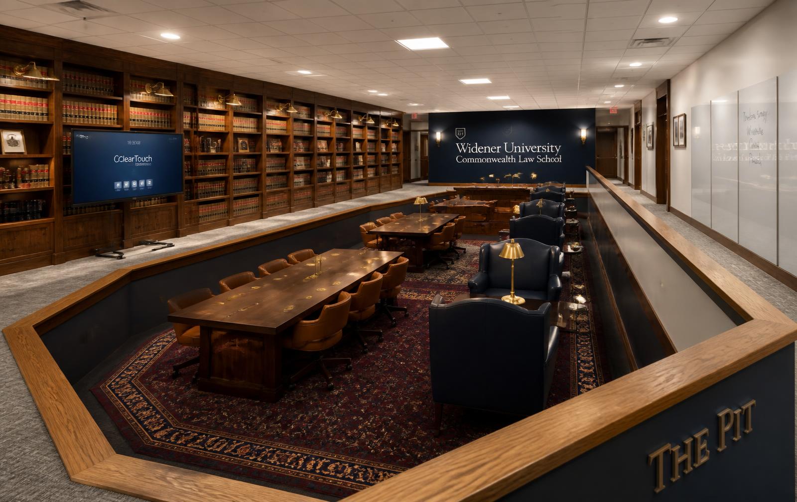 Overview of the Library concept with walnut bookcases, communal reading tables and navy reading chairs